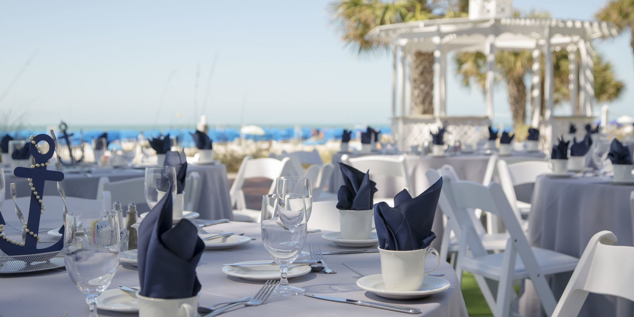 A Group Of People Sitting At A Table With Wine Glasses