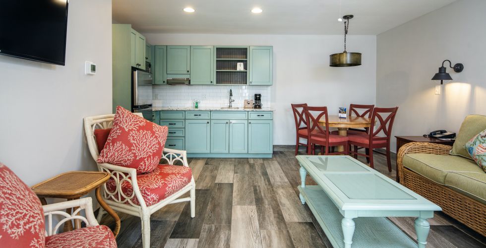A Living Room With A Green Table And Chairs