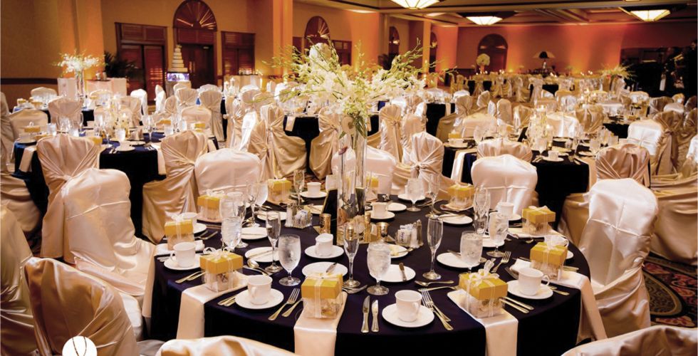 A Group Of People Sitting At A Table With Wine Glasses