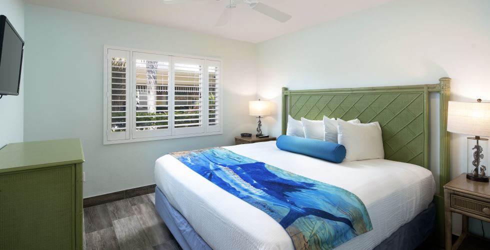 A Bedroom With A Bed And A Fan