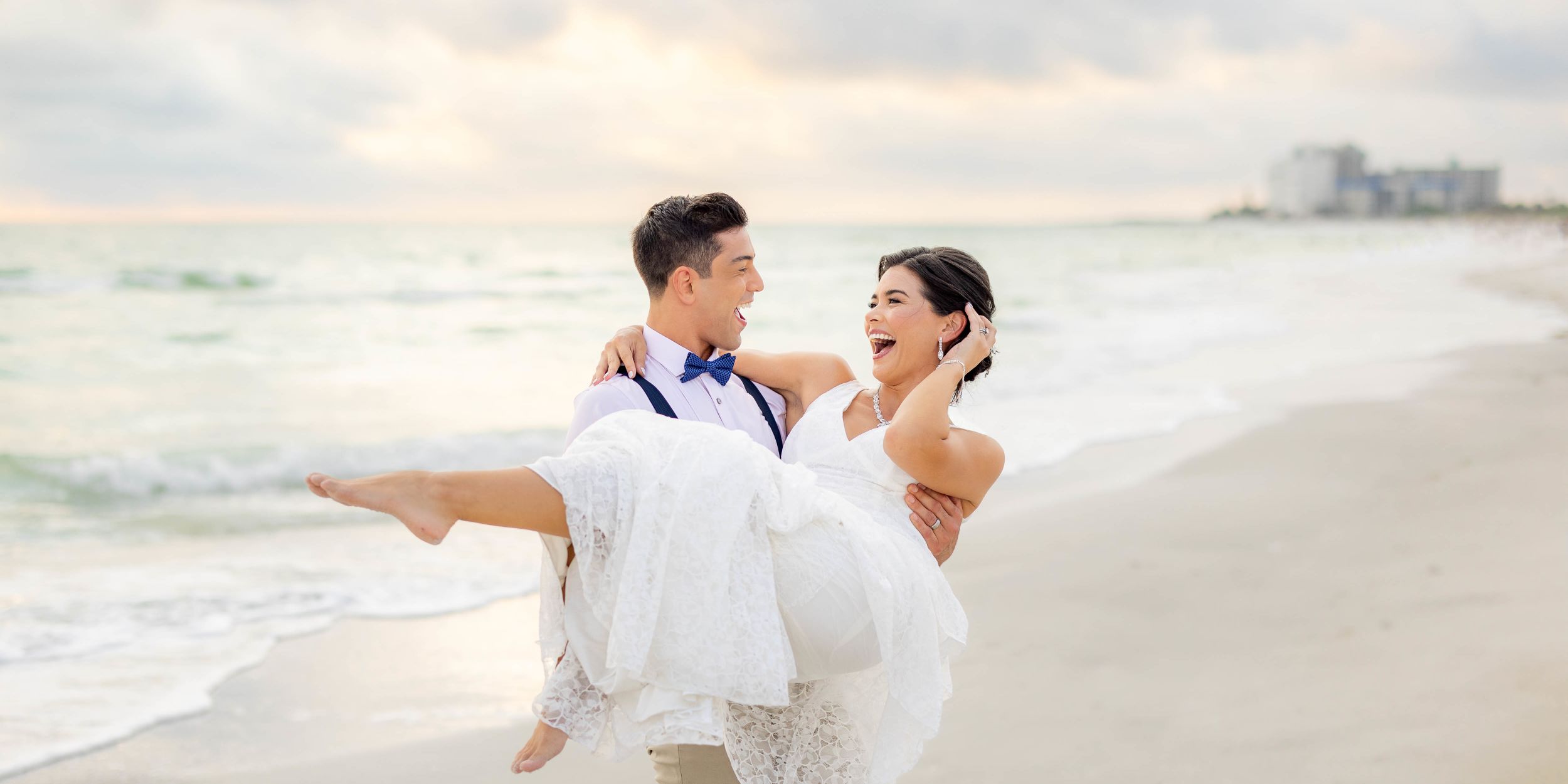 A Man And Woman Holding Each Other On A Beach