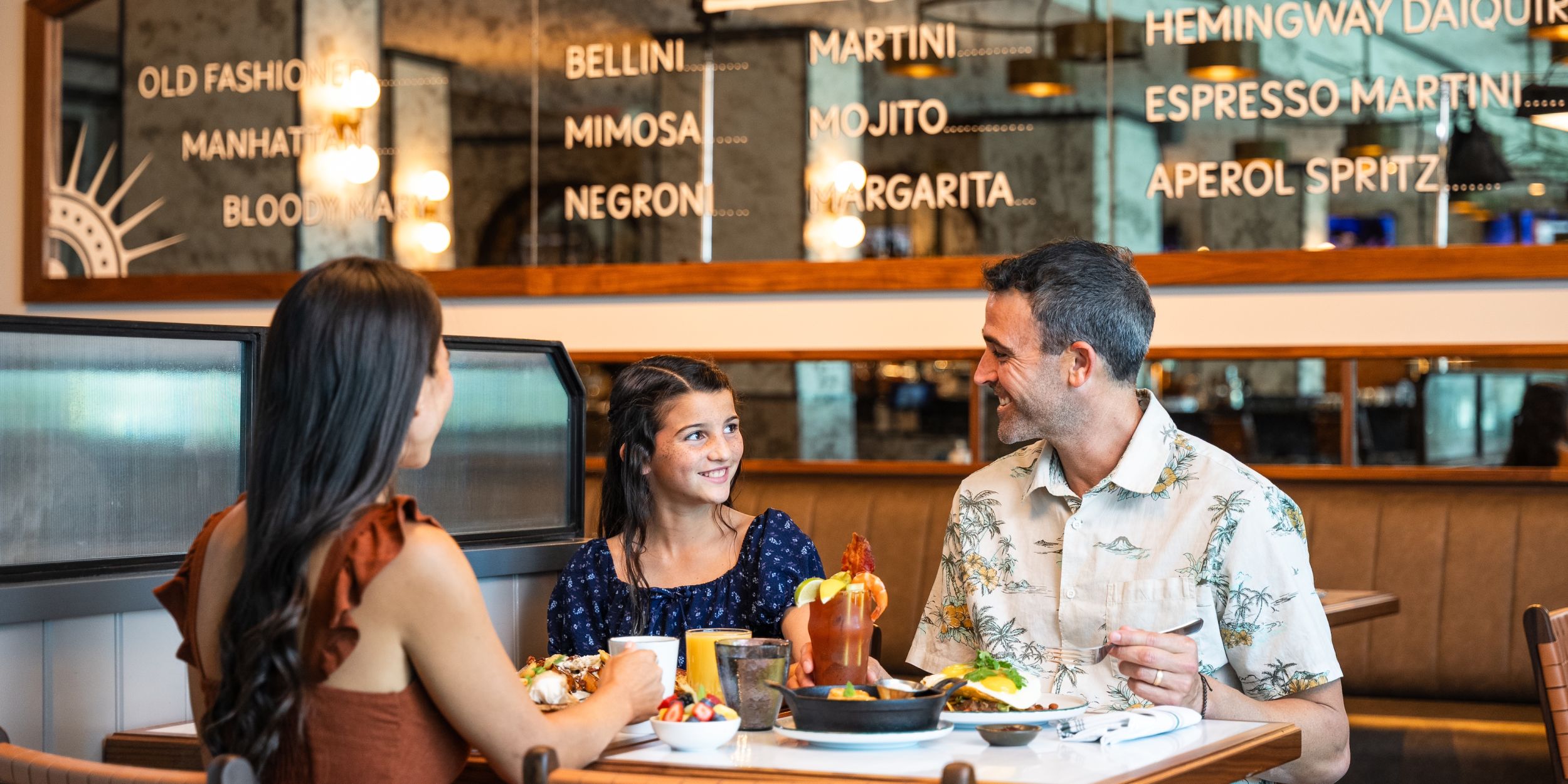 A Group Of People Sitting At A Table Eating Food