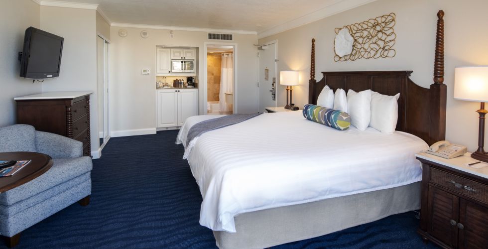 A Bedroom With A Bed And Desk In A Hotel Room