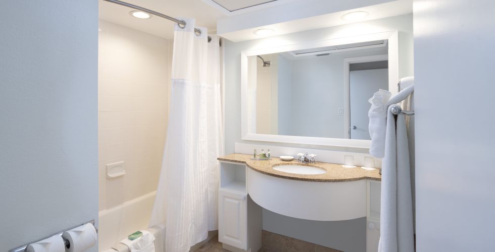 A Room With A Sink And A Mirror