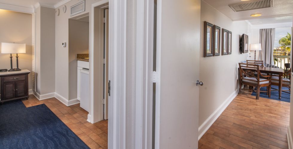 A Room With A Blue Carpet And A Wood Floor With A White Wall With Art On It