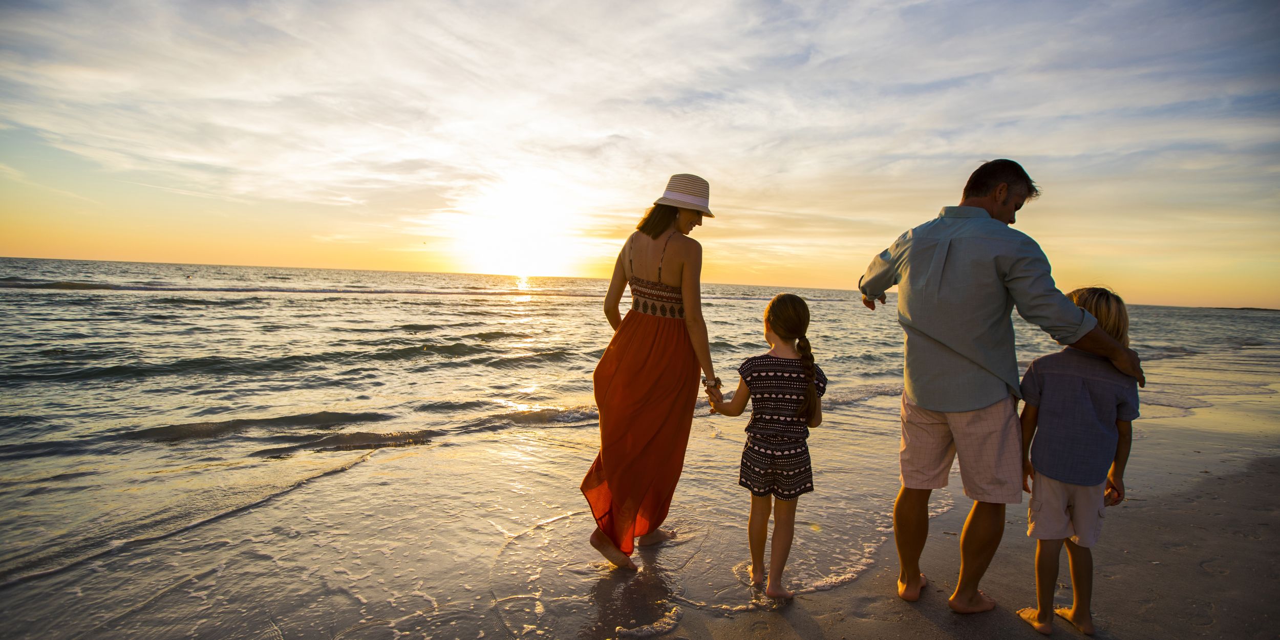 A Couple Of People Standing On A Beach