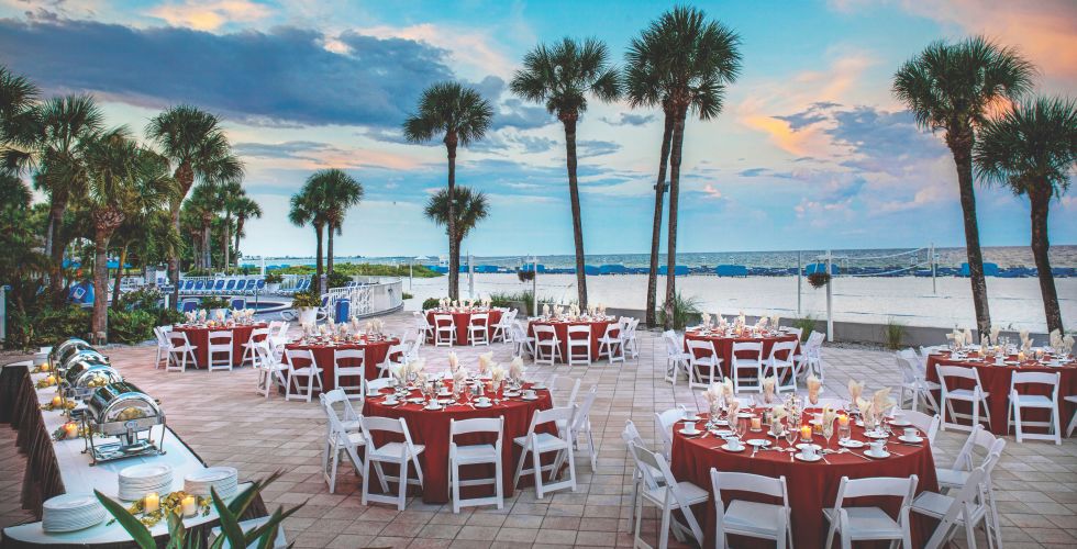 A Group Of Lawn Chairs Sitting On Top Of A Sandy Beach